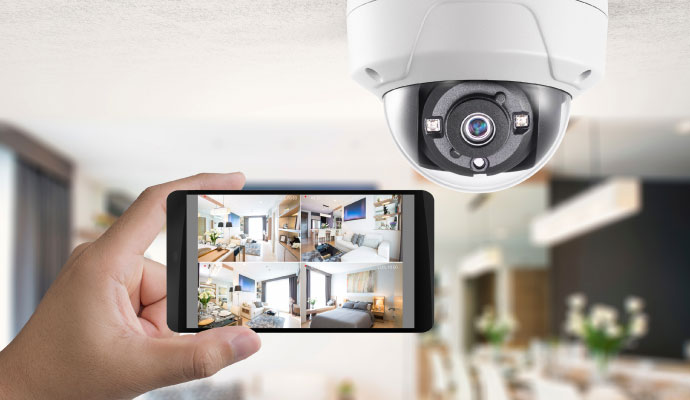 a person viewing the feeds of their security cameras on their<br />
      phone