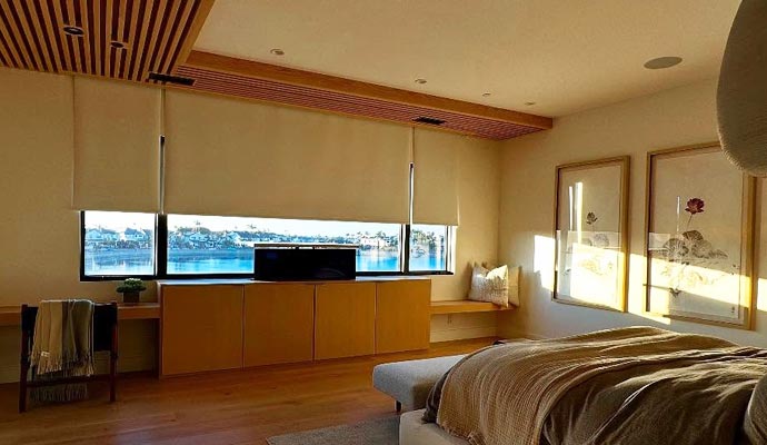 Modern bedroom featuring motorized window coverings for convenience and light control