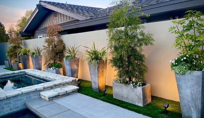 Modern backyard with stone pool and warm outdoor lighting