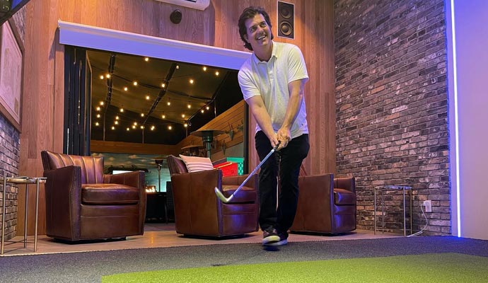 Person playing golf indoors using a simulator