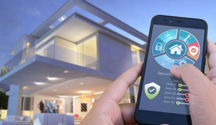 Person using a smartphone app to control smart home automation features in front of a modern house
