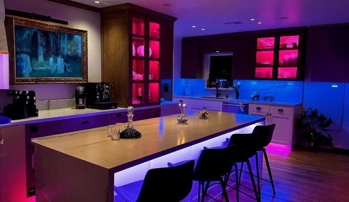 Stylish modern kitchen featuring ambient smart linear lighting under cabinets and along shelves