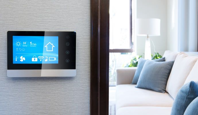 Wall-mounted smart climate control panel displaying temperature, fan and connectivity icons in a modern living room