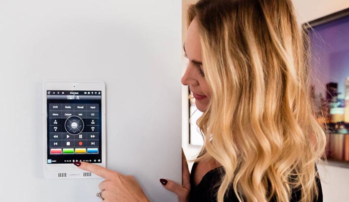 Woman using wall mounted smart home control panel