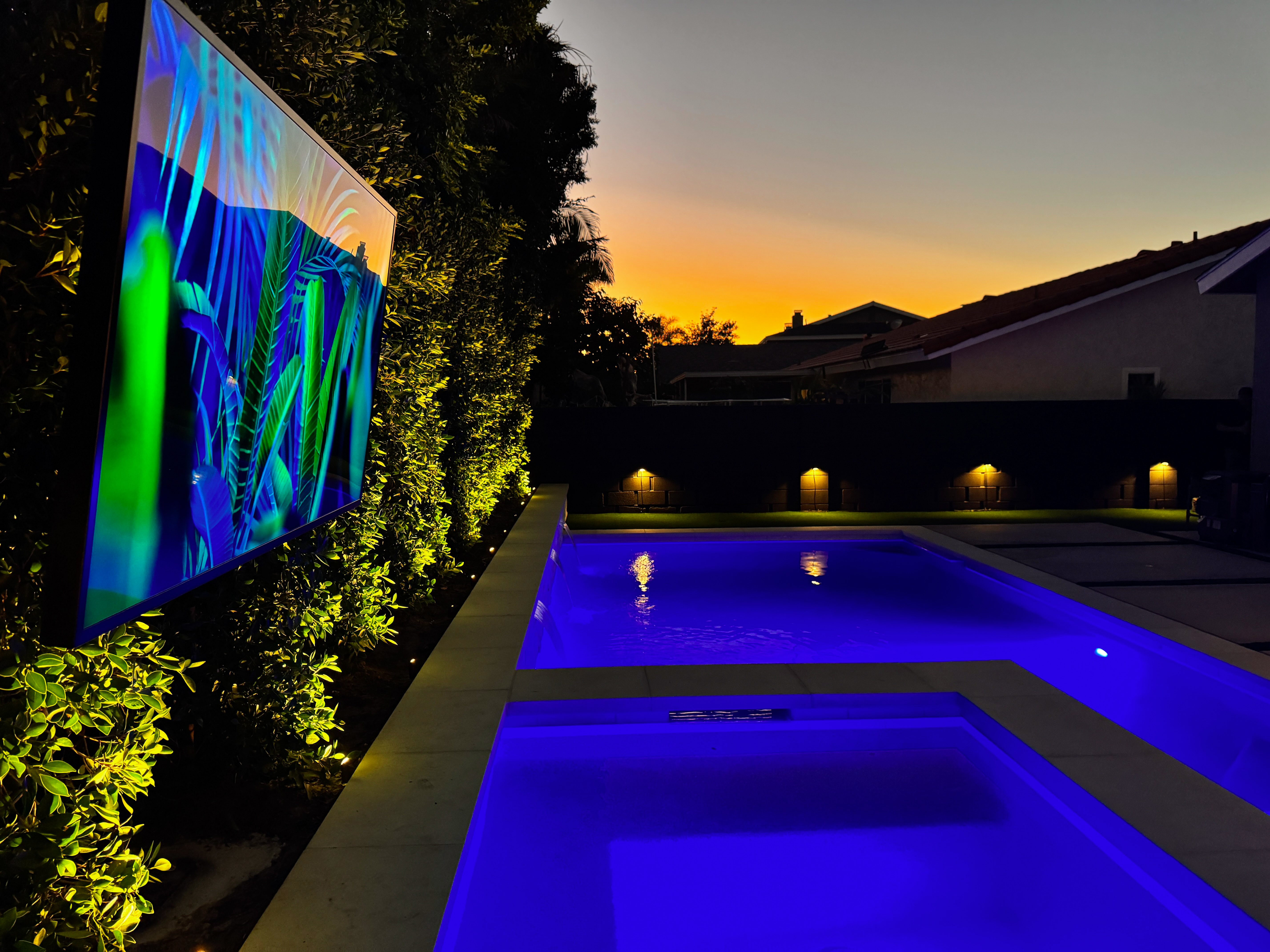 A Samsung TV alongside elegant Coastal Source lighting, perfectly blending with the backyard’s style and ambiance.