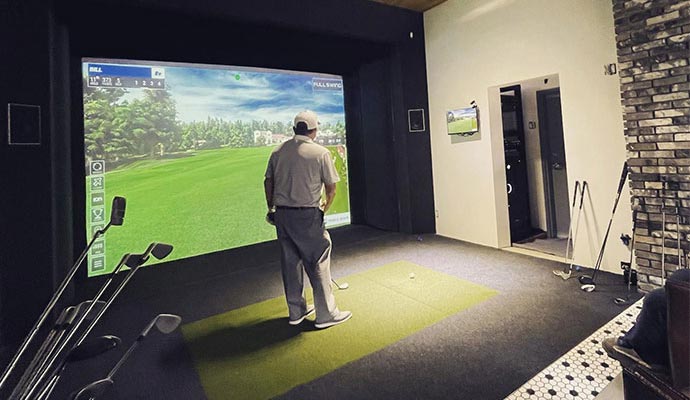 a person playing golf with a golf simulator